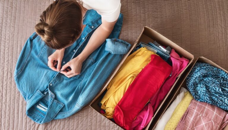 overhead view of woman preparing clothes for donation